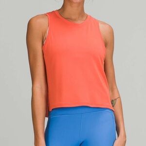 Lululemon Train to Be Tank Top in a coral/orange color.